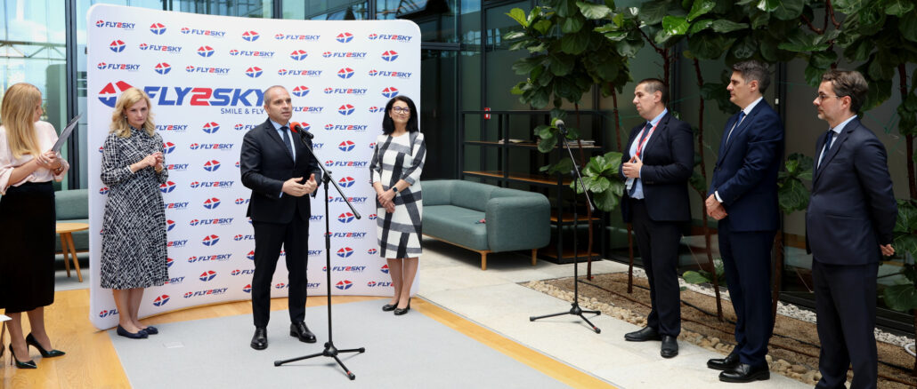 a group of people standing in front of a wall with microphones