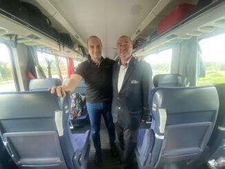 two men standing in a train