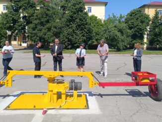 a group of people standing around a yellow and red object